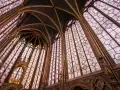 Interior de una capilla con vidrieras de colores y bóvedas ojivales, un ejemplo impresionante del estilo gótico.