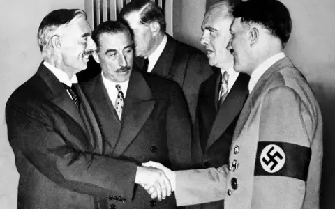 Neville Chamberlain y Adolf Hitler se dan la mano en la conferencia de Múnich, un momento clave de la historia.