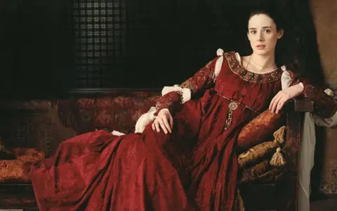 Juana la Loca, vestida de rojo, reflexiona sobre cuántos hijos tuvo.