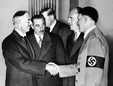 Neville Chamberlain y Adolf Hitler se dan la mano en la conferencia de Múnich, un momento clave de la historia.